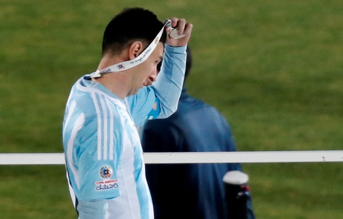 Logo depois de receber a medalha pelo vice-campeonato, Messi a tira do peito (Foto: AP)