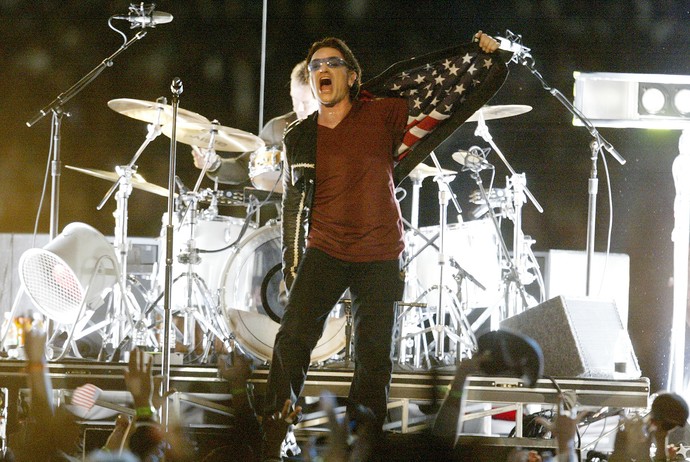  Bono Vox mostrando o forro do terno U2 superbowl 2002 (Foto: Jed Jacobsohn / Getty Images)